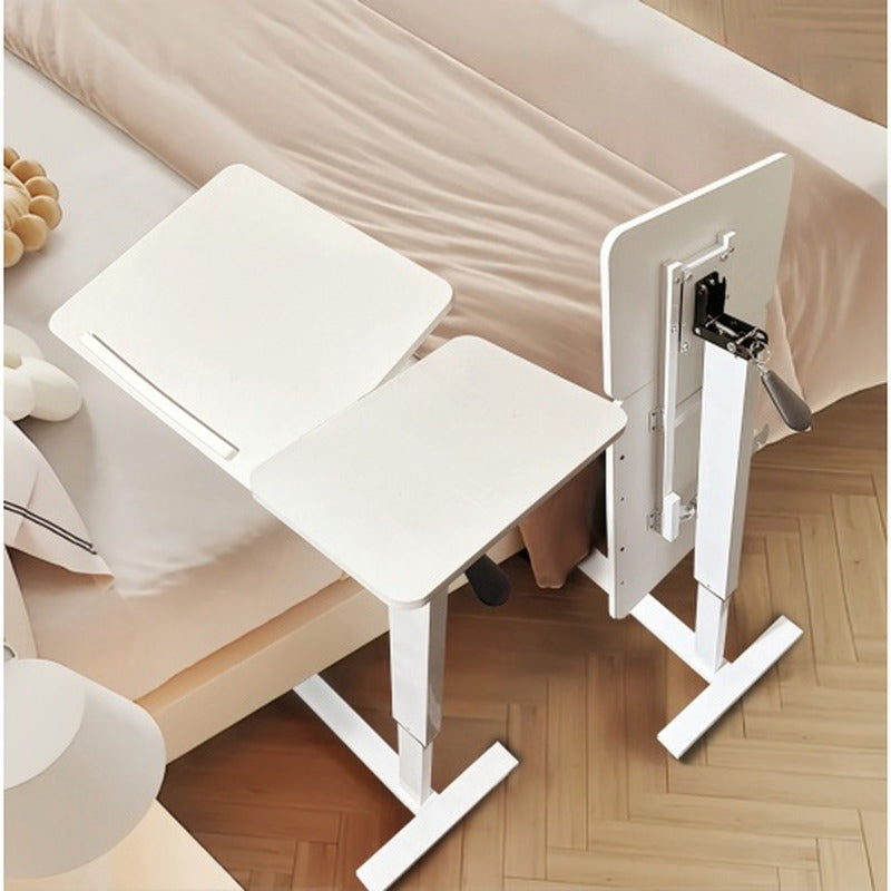 White adjustable overbed laptop table beside a sofa and bed with wheels