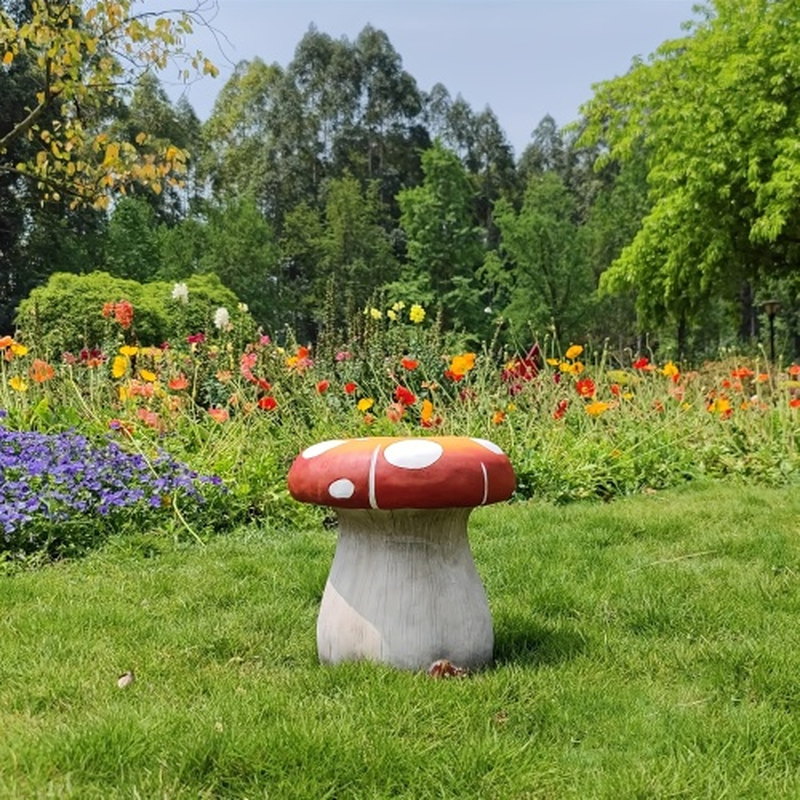 Oversized mushroom statue stool styled in a colorful garden lawn