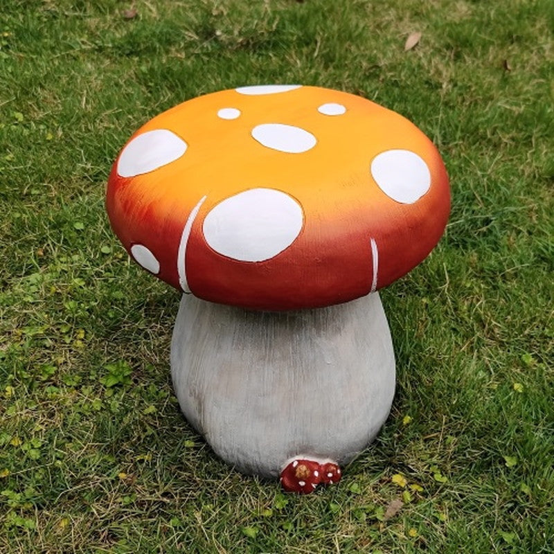 Orange mushroom garden stool front view on grass