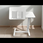 Top view of white overbed table showing tilting desktop and side tray