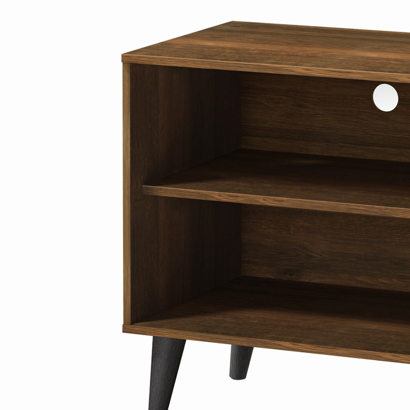 Open shelf storage detail on brown TV stand for electronics and media devices